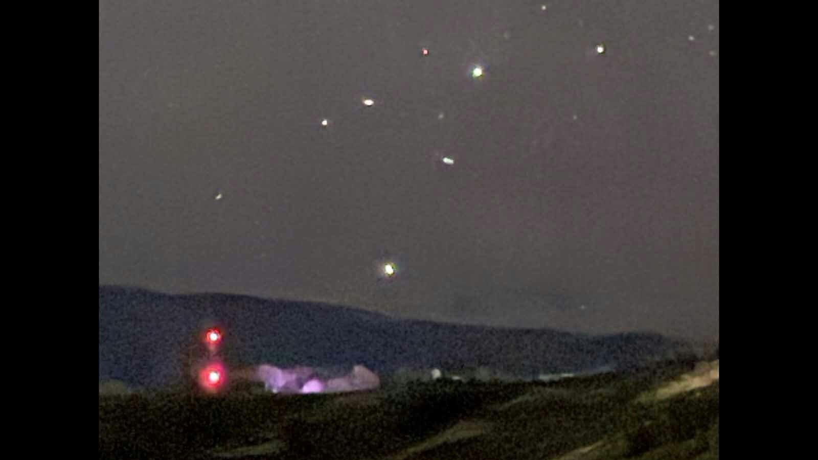 Mysterious lights rise in the night sky over Cedar Mountain near Cody, Wyoming.