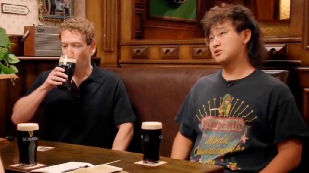 Mark Zuckerberg and Alexander Wang sit at a pub booth with pints of Guinness on the table in front of them.